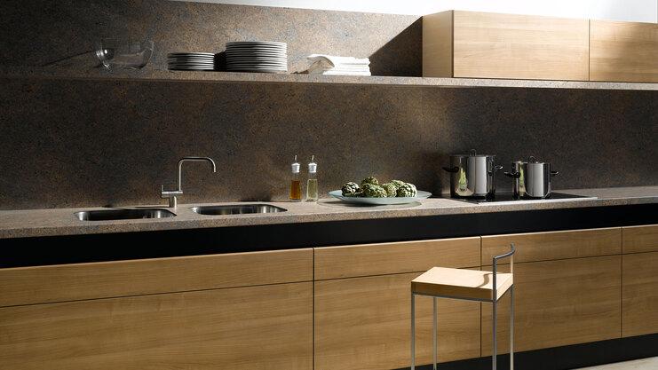 Küchenzeile aus Massivholz mit dunkler Arbeitsplatte Küchenzeile aus Massivholz mit schwarzer Arbeitsplatte, Spülbecken und Wandregal