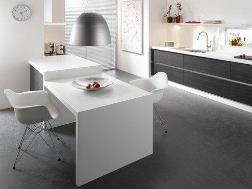 Impression einer einzeiligen Küchengestaltung in schwarz-weiß mit Esstisch für Zwei